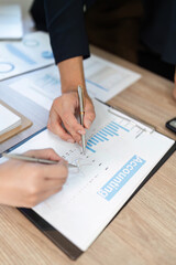 Analyzing Financial Data. Close-up of hands reviewing accounting charts and graphs in a business meeting.