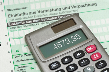 Ein Taschenrechner liegt auf einem Formular für die Steuererklärung für Einkünfte aus...