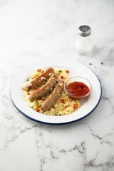 Grilled sausages with couscous and tomato sauce