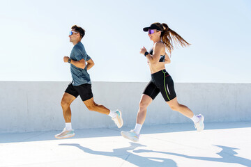 Fit individuals enhance their fitness during an energetic morning run along a sunlit outdoor track
