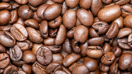 Fresh coffee beans scattered as a background or texture.
