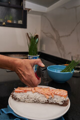 hands making fresh sushi at home
