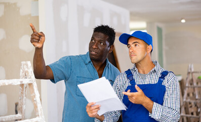 Owner of apartment indicates to the foreman where and what to repair