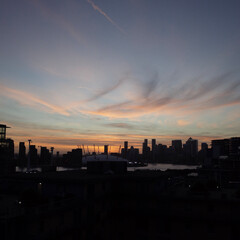Obraz premium Sunset Silhouette of Canary Wharf and O2 Arena Skyline in London, UK
