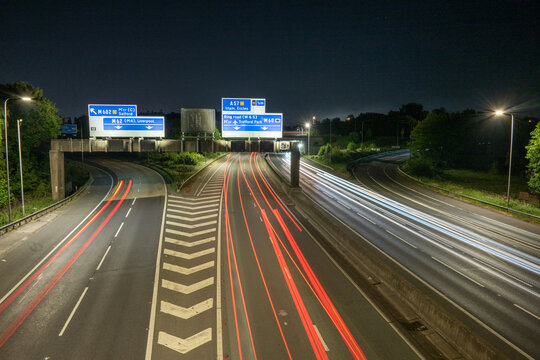 M60 Motorway junction at night with light trails. Junction signs can be seen