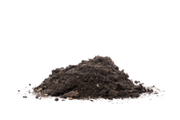 A mound of dark soil or dirt isolated against a plain black background in a studio setting view