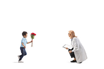 Full length profile shot of a boy bringing flowers to a female doctor
