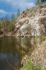 Experience the serene beauty of a river landscape, where cliff reflections dance in the tranquil...