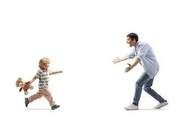 Boy with a teddy bear running towards a man