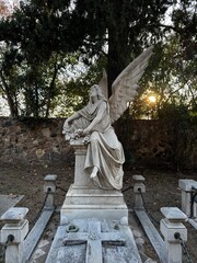 Montjuïc Cemetery in Barcelona at sunset, with dramatic lighting casting long shadows over...