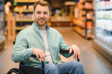 Smiling customer in wheelchair shopping for groceries in supermarket