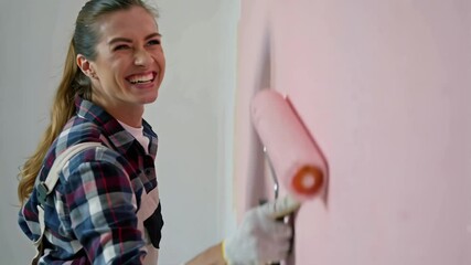 positive woman with paint roller, apartment renovation