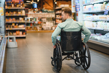 Obraz premium Customer using wheelchair choosing groceries in supermarket