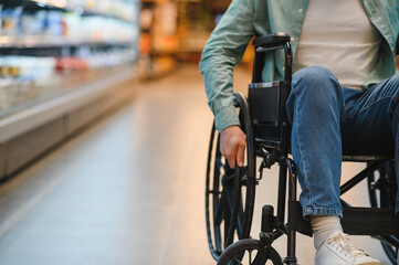 Customer using wheelchair shopping for groceries in supermarket