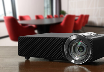 Modern video projector on wooden table in conference room