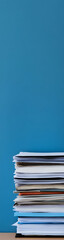 Stack of Paper Documents on Desk with Blue Background &ndash; Office Organization and Paperwork Concept - vertical banner - wide skyscraper 