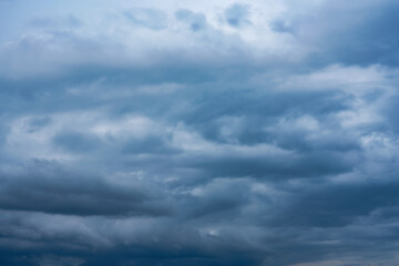 storm clouds gather across the blue sky during the rainy season, forming dramatic shapes as nature signals an approaching storm over the open landscape.