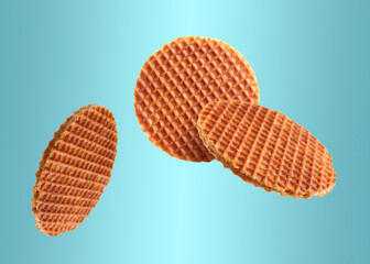 Yummy Dutch waffles (stroopwafels) flying on light blue gradient background