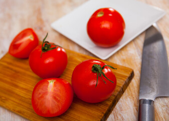 Delicious ripe tomatoes on a wooden chopping board. Ingredients for cooking