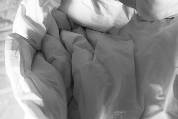 Clean crumpled white bed sheet and pillow after use in the bedroom. Image use for travel and resort business presentation background.
