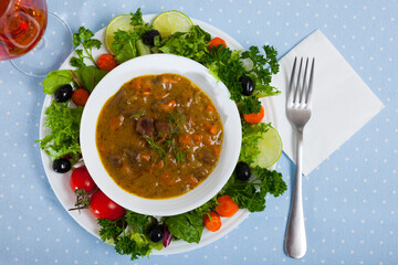 Chicken heart goulash served in ceramic bowl with vegetables