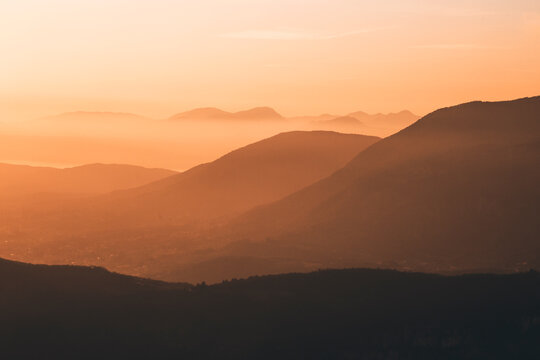 sunset in the mountains with orange sky and mountain silhouettes