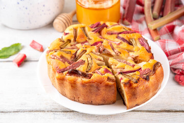 Summer homemade baking, tasty rhubarb pie. Sweet seasonal dessert recipe, sponge cake with rhubarb slices on top and sweet jam inside