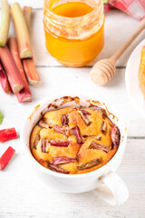 Summer homemade baking, quick microwave made cupcake, mugcake. Simple sweet seasonal dessert recipe, sponge cake with rhubarb slices on top and sweet jam inside