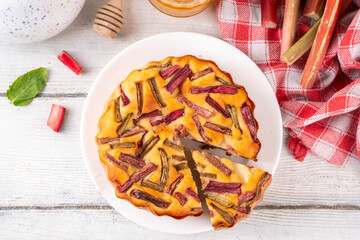 Summer homemade baking, tasty rhubarb pie. Sweet seasonal dessert recipe, sponge cake with rhubarb slices on top and sweet jam inside
