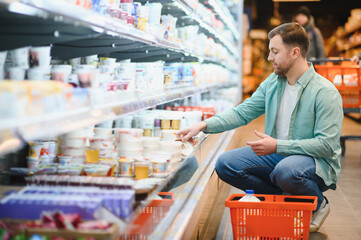 Customer choosing yogurt in refrigerated section of supermarket