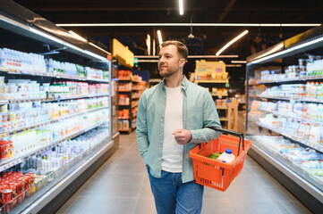 Customer choosing products, walking through supermarket aisles