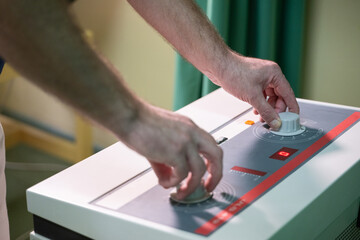 Physiotherapy Device Adjustment. Close up of hands adjusting settings on a physiotherapy device used for therapeutic treatment in a clinic.