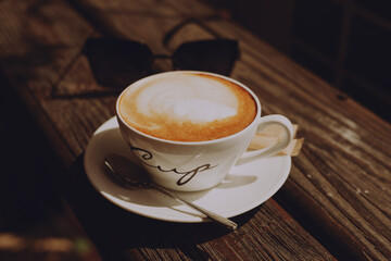 Cup of cappuccino on wooden background