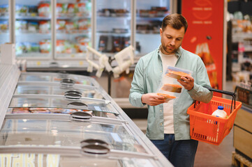 Customer choosing frozen food in supermarket refrigerator section
