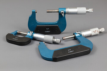 Three blue micrometers with various sizes, a micrometer is a tool to precisely measure the outer...