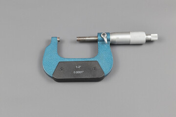 A blue micrometer isolated on grey background, A micrometer is a tool to precisely measure the...