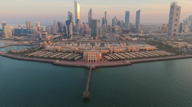 Stunning 4K drone shot of Marina Crescent in Kuwait with a golden sunrise over iconic skyscrapers and the waterfront. Perfect for tourism, architecture, and cityscape themes.