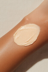 Fototapeta premium Close-up of a person's arm with a dollop of light beige cream or lotion applied. The cream has a thick, smooth texture. Skin care application.