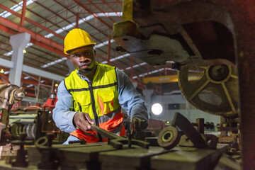 Black male factory industry engineer working with machinery in manufacturing industry