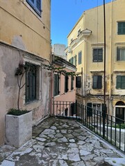 Golden hour view of Corfu Town (Kerkyra) on the island of Corfu, Greece. Warm sunlight bathes the historic buildings, narrow streets, and coastal architecture, highlighting the charm of this Mediterra
