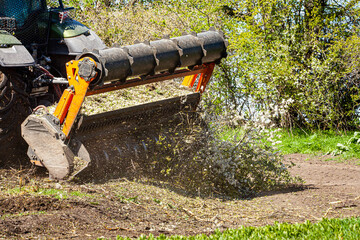 Picture of a tractor specialized in forest clearing that is in the process of destroying all the trees and bushes. Stop deforestation. Picture of a large tractor that destroys nature.