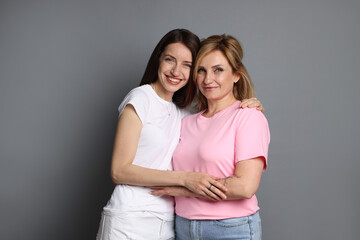 Portrait of mother and daughter on grey background
