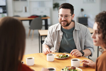 Colleagues chatting during lunch break in office