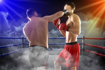 Boxers surrounded by smoke fighting in ring. Sporting event