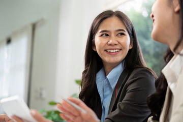 Obraz premium Positive Interaction and Teamwork. Smiling businesswoman engaging in conversation with colleague.