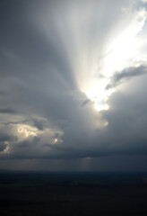 Naklejka premium sun is shining through the clouds in the sky
