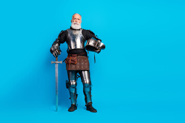 Portrait of a senior man wearing medieval knight armor, standing with a sword against a vibrant...