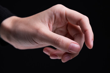Female hands on a black background. Concept of tenderness and self-care.