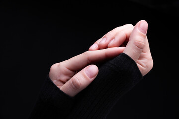Female hands on a black background. Concept of tenderness and self-care.