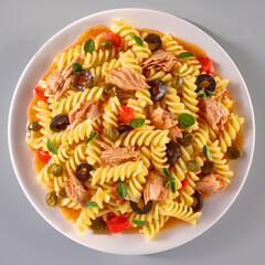 Pasta mit Tomaten Oliven Kapern auf weissem Porzellanteller,  Topshot, Nudeln, Fussili, 
